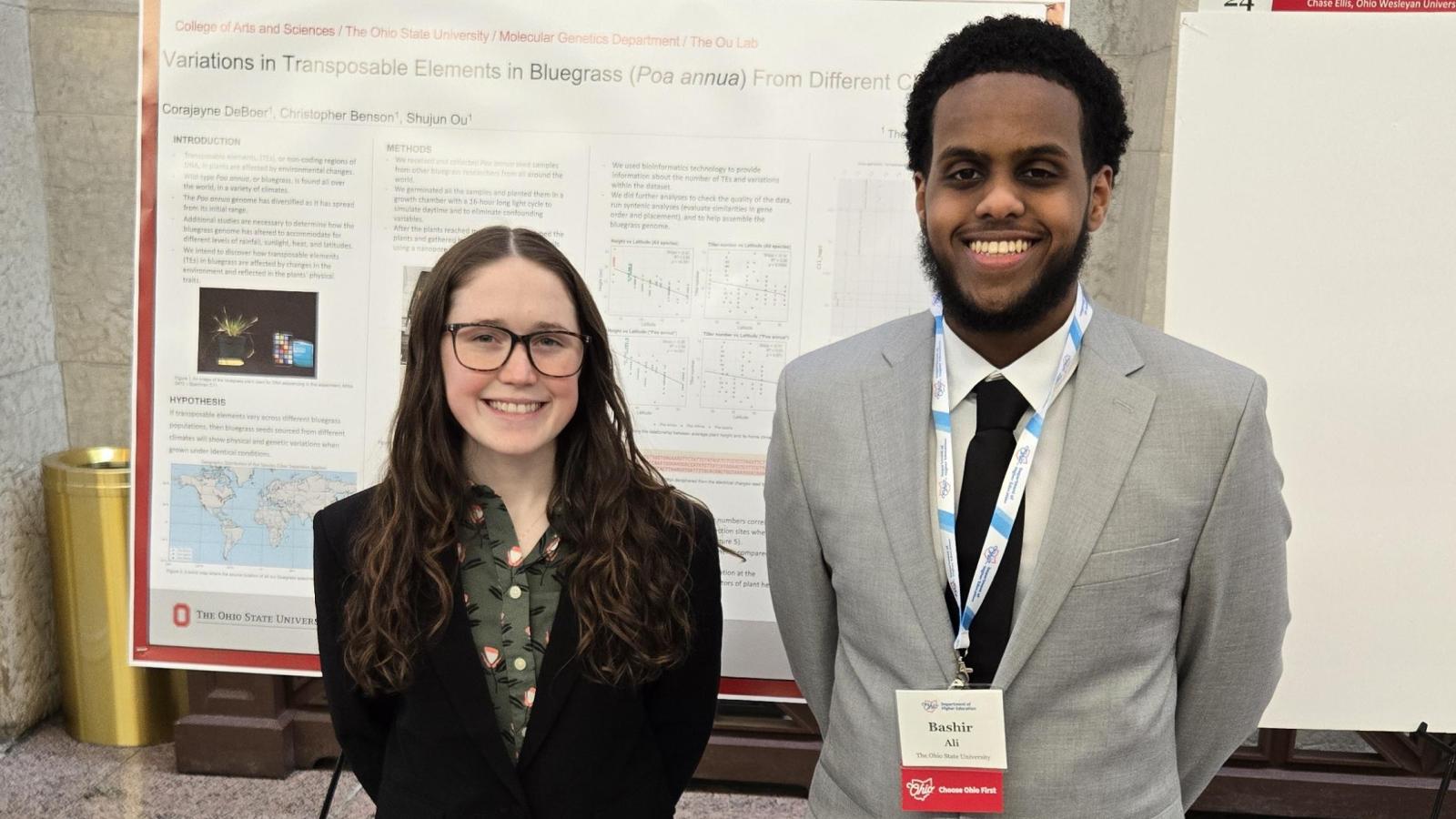 Corajayne and Bashir in front of poster presentations