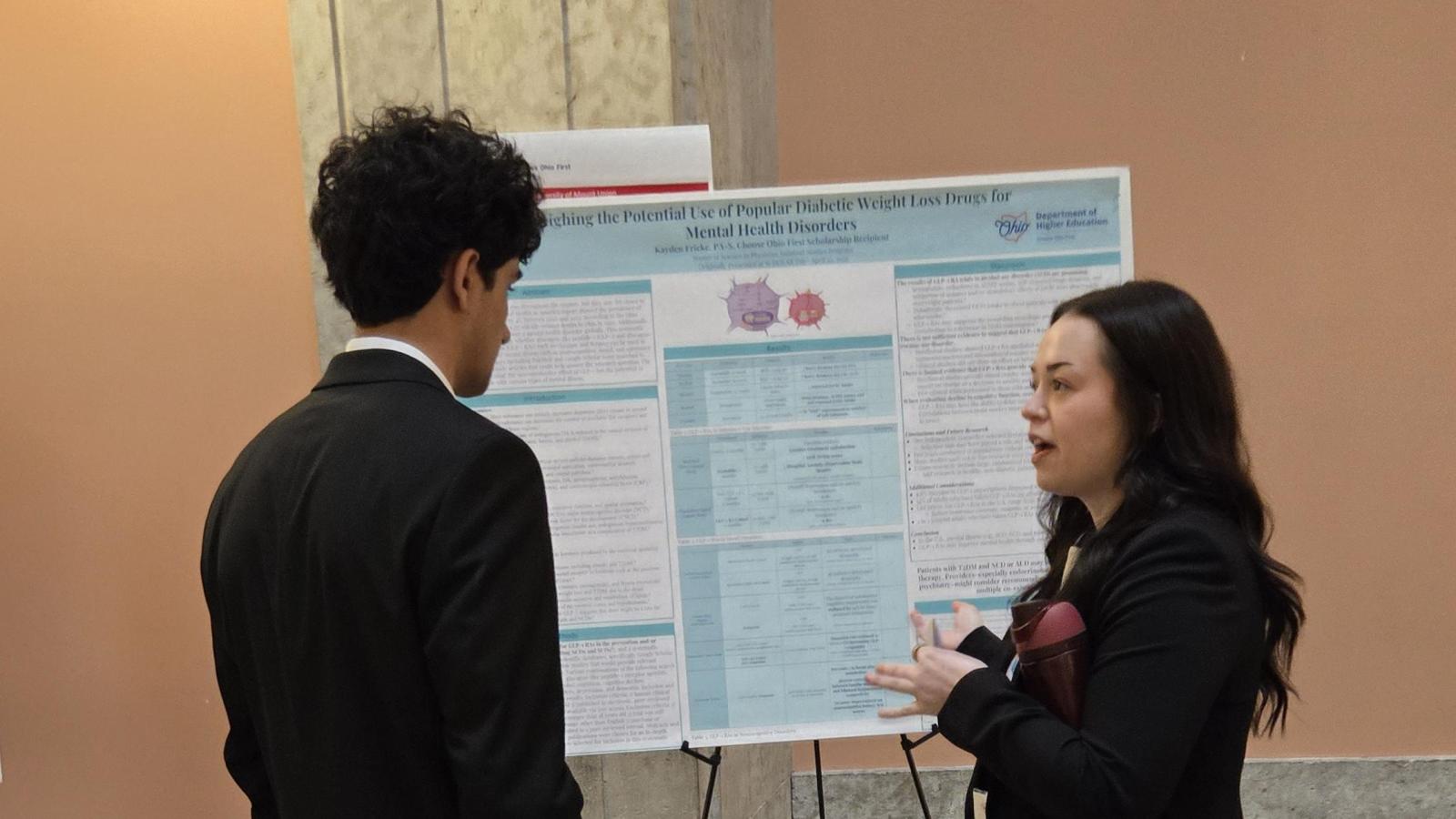 Faisal listening to another student presenting